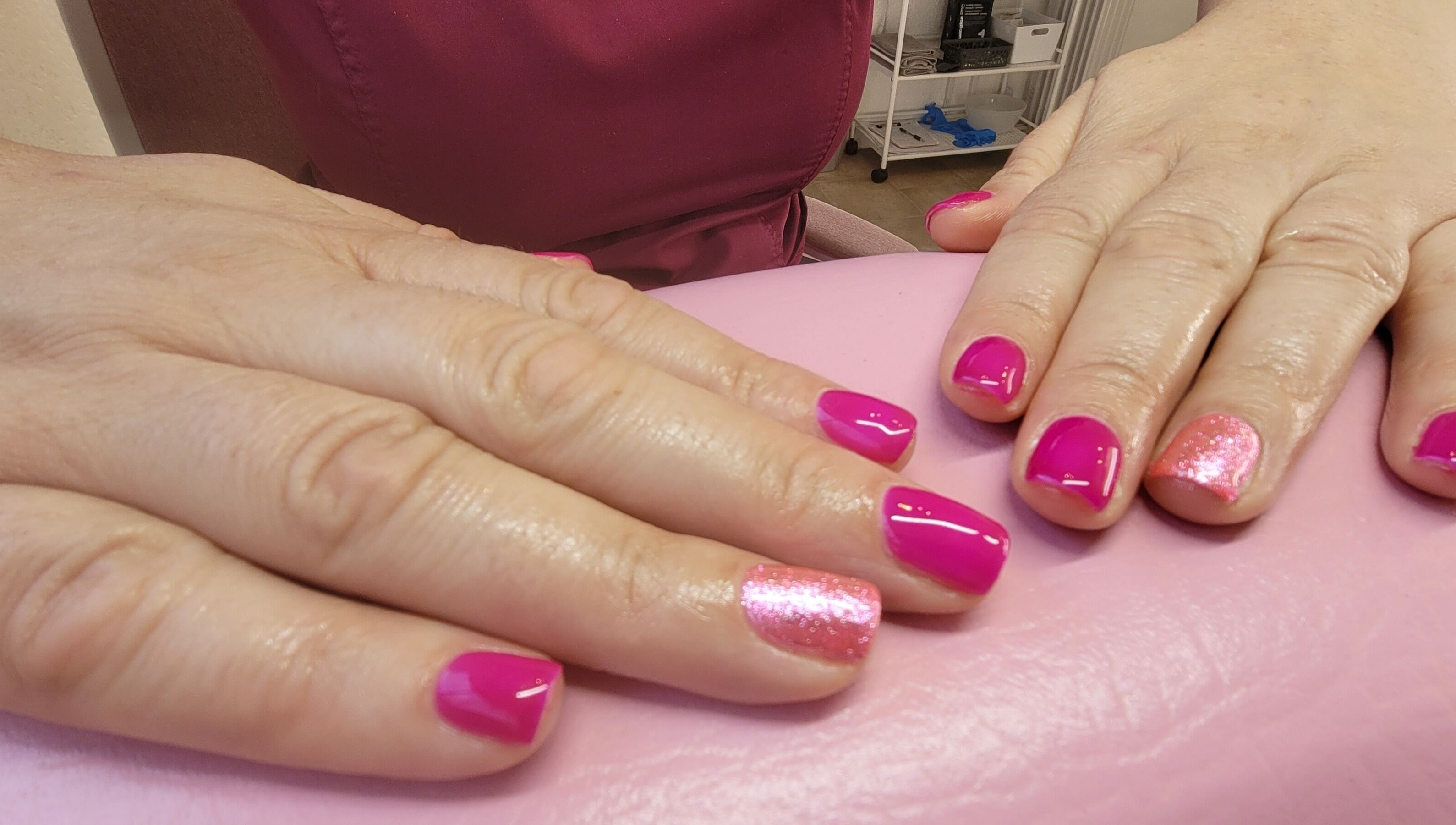 Bright pink nails with glitter accent at Lucy's Beauties, Queen Camel, England, GB.