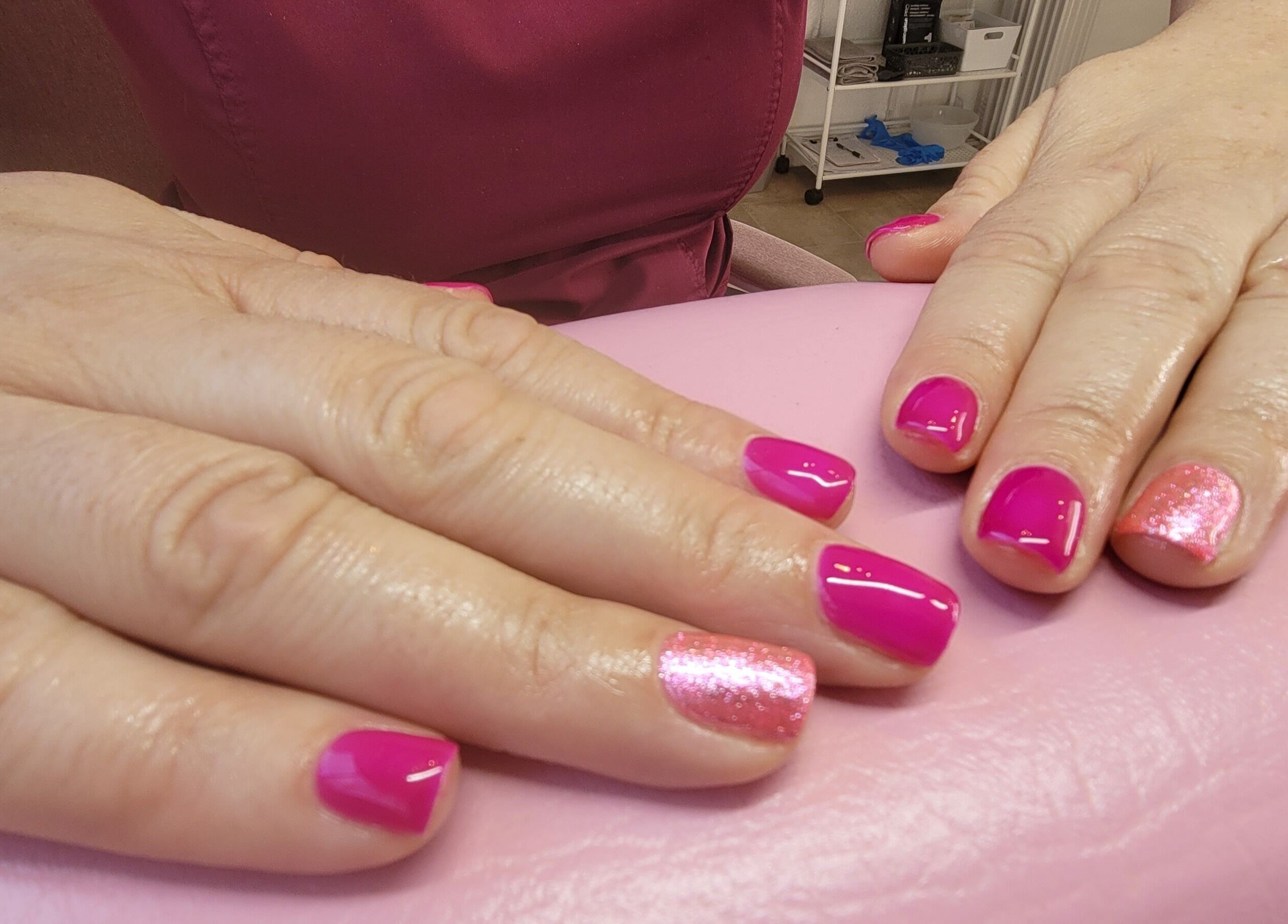 Bright pink nails with glitter accent at Lucy's Beauties, Queen Camel, England, GB.