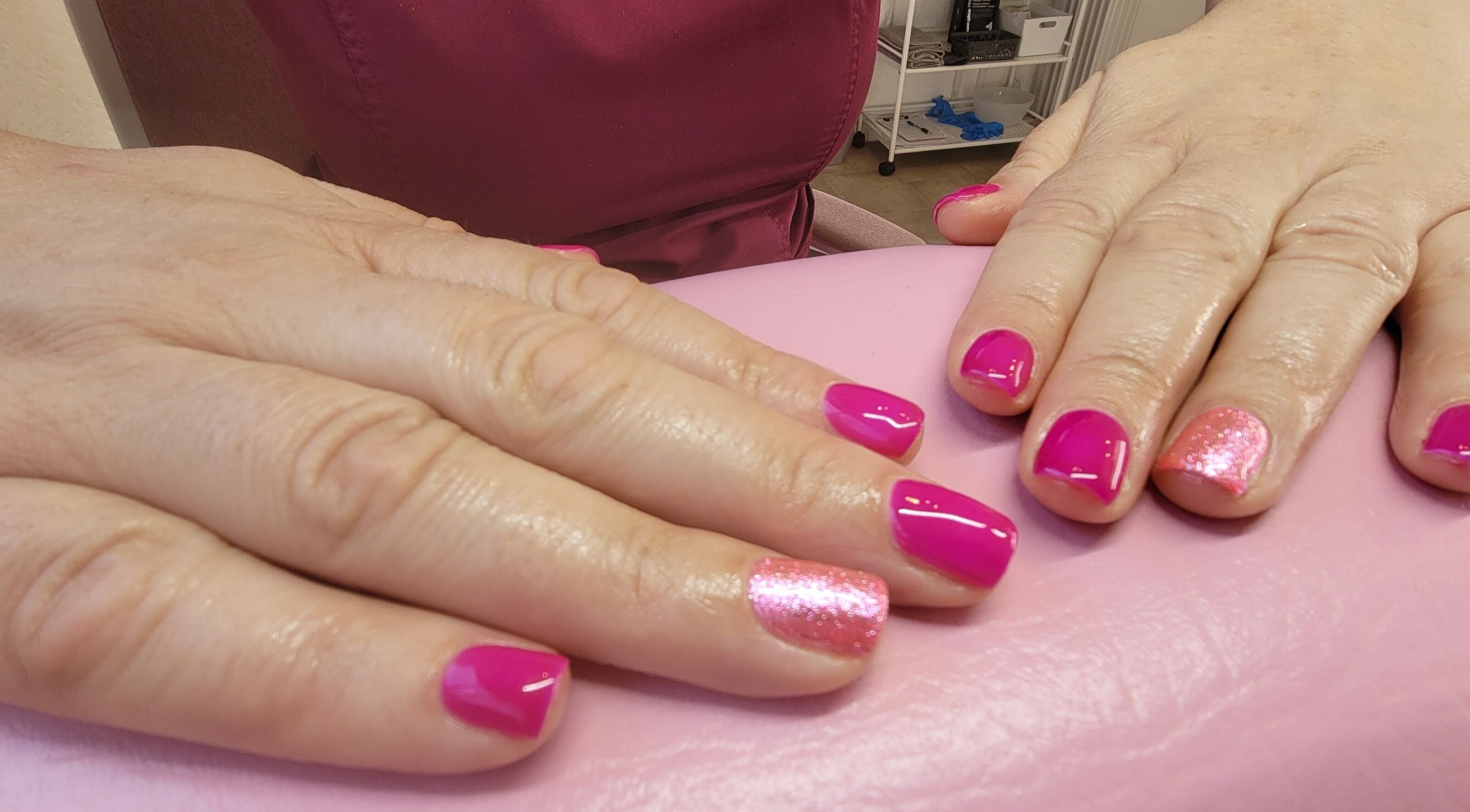 Bright pink nails with glitter accent at Lucy's Beauties, Queen Camel, England, GB.