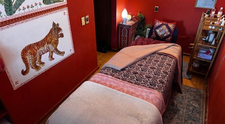 Sala de relajación en KB Studio, La Reina, Región Metropolitana, CL. Decoración roja acogedora y cama de masajes.