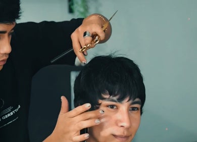 Estilista en Bastardos Studio, Guernica, Buenos Aires, realiza un corte de cabello.