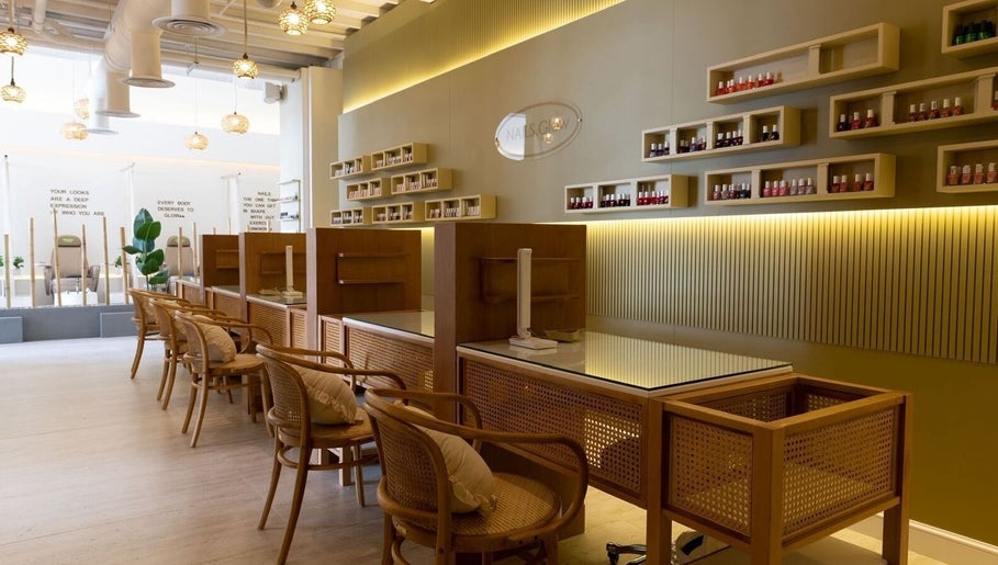 Modern interior of Nails Glow - Al Rawdah, Riyadh, showcasing nail polish wall display and cozy seating.