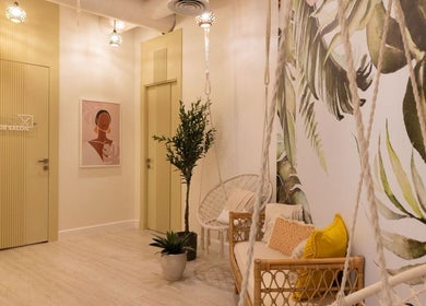 Elegant salon interior at Nails Glow - Al Rawdah, Riyadh with tropical decor and cozy seating.