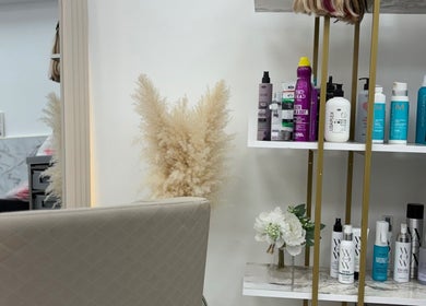 The Flahive Effect salon in Hereford, England, GB showcasing a shelf with beauty products and pampas grass decor.