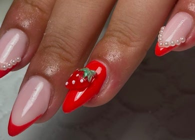 Nail art fraise à Nouny Nails Lab, Avignon, Provence-alpes-côte D'azur, FR. Ongles embellis de perles et motifs rouges.