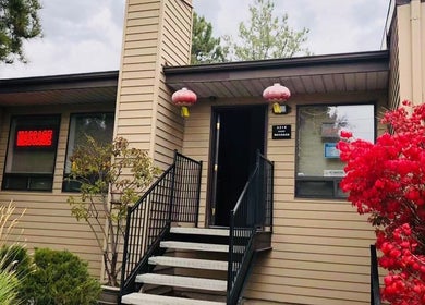 Entrance of Chinese Massage Oasis with vibrant plants, located in Salt Lake City, Utah, US.