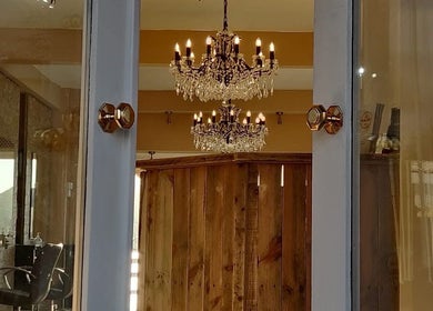 Luxurious chandelier reflections inside HBL LONGRIDGE salon, Longridge, England, GB with wooden panel decor.
