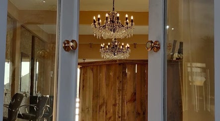 Luxurious chandelier reflections inside HBL LONGRIDGE salon, Longridge, England, GB with wooden panel decor.