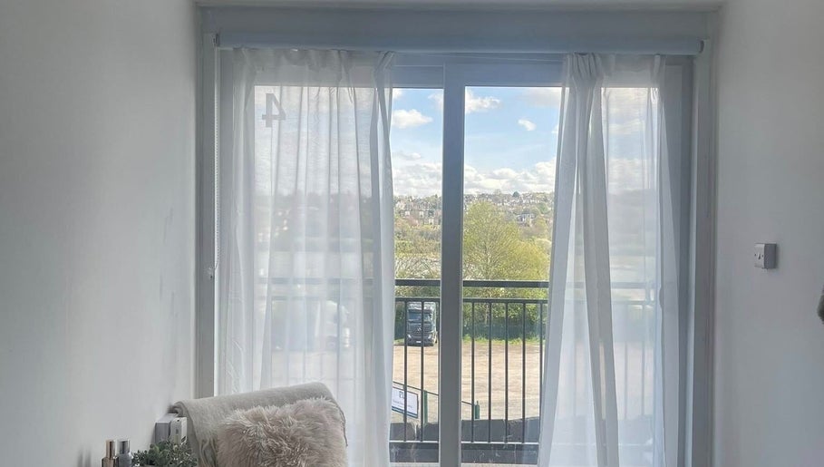 Relaxing view from Glamour Nails in Rochester, England, GB showcasing peaceful scenery through sheer curtains.