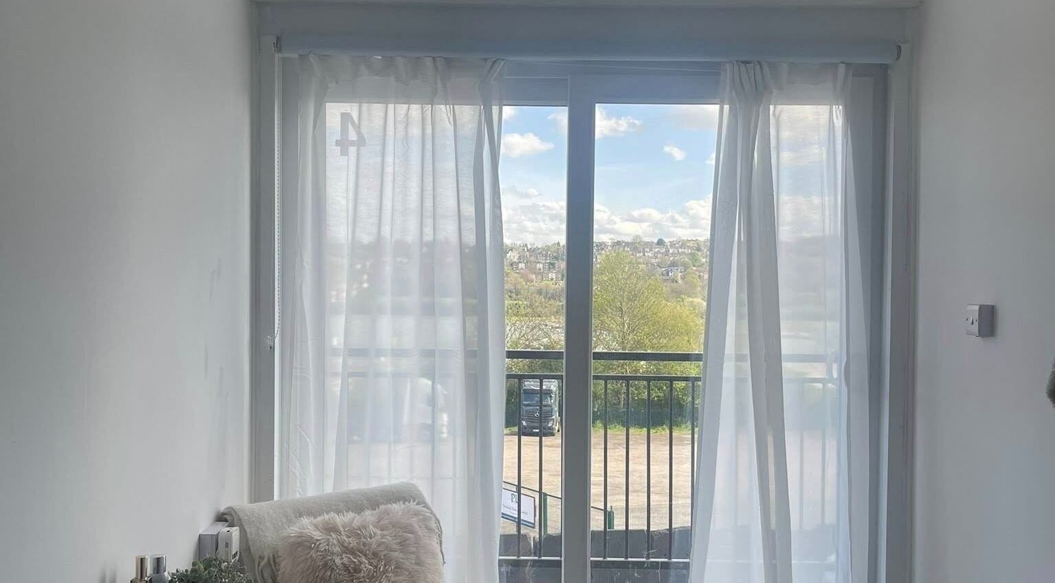 Tranquil view from Glamour Nails in Rochester, England, GB featuring sheer curtains and peaceful outdoor scenery.