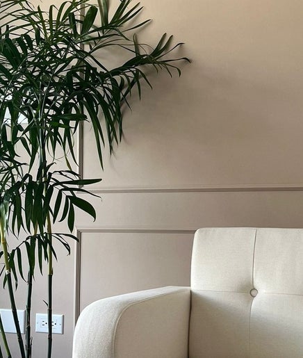 Relaxing lounge with white armchair and plant at Detox Spa, Georgetown, KY.