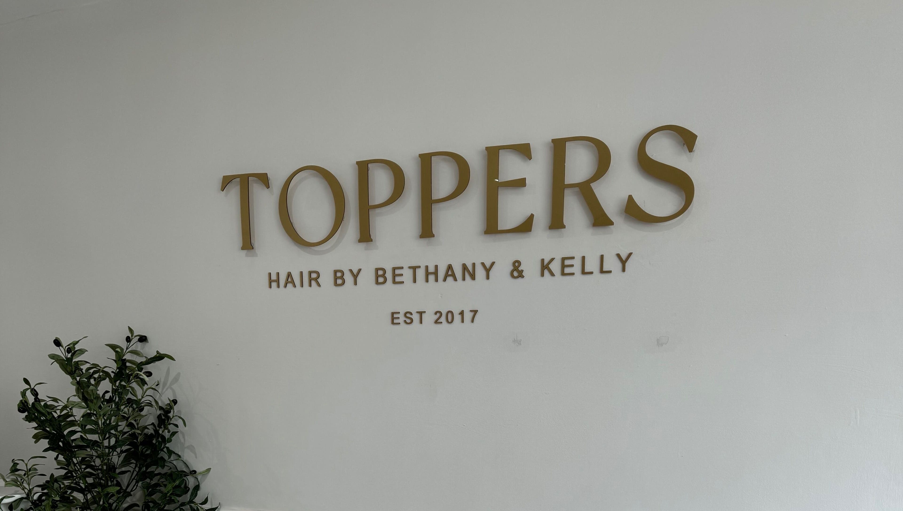 Elegant signage of Kelly Guppy Hair in Exeter, England, GB welcoming clients with style.