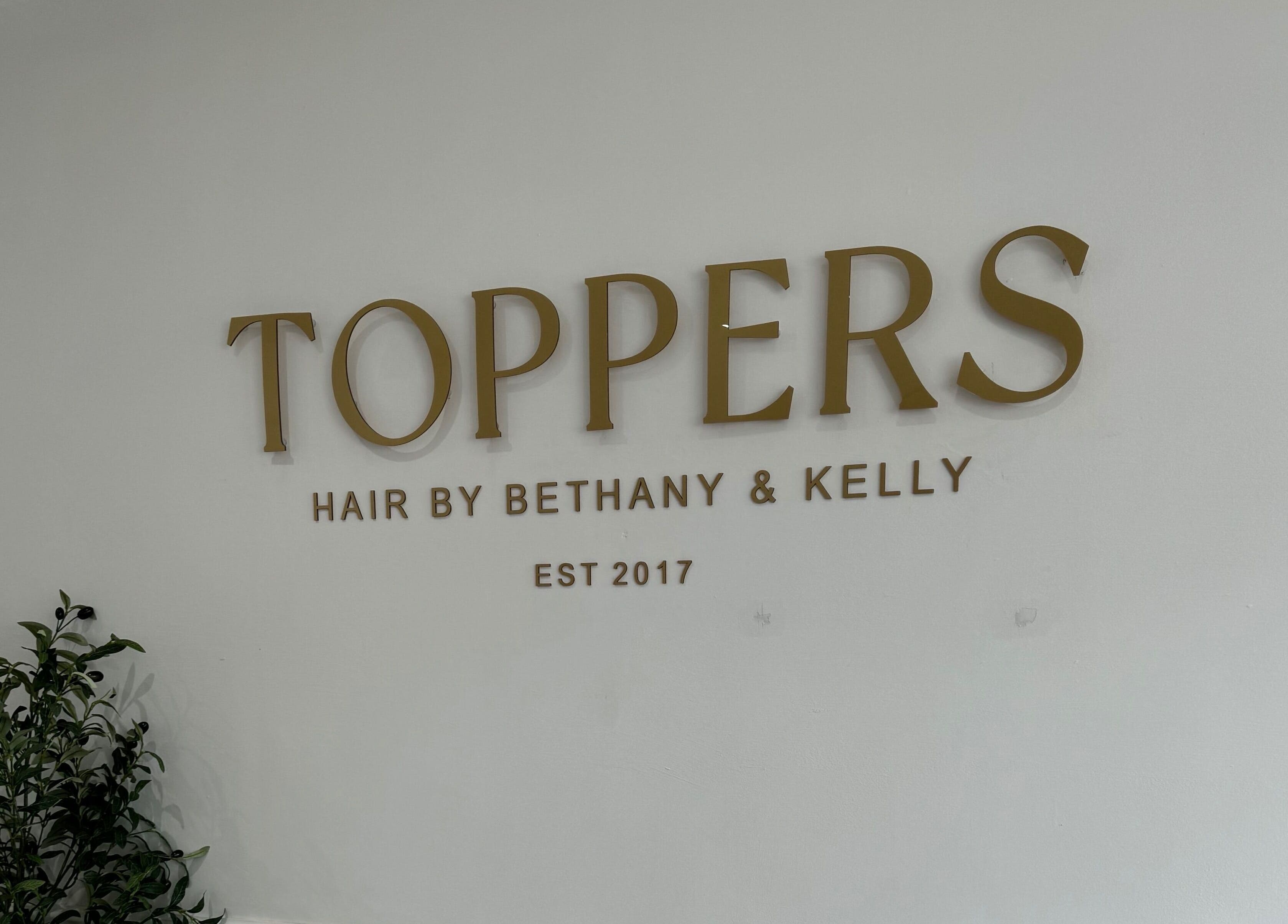 Elegant signage of Kelly Guppy Hair in Exeter, England, GB welcoming clients with style.