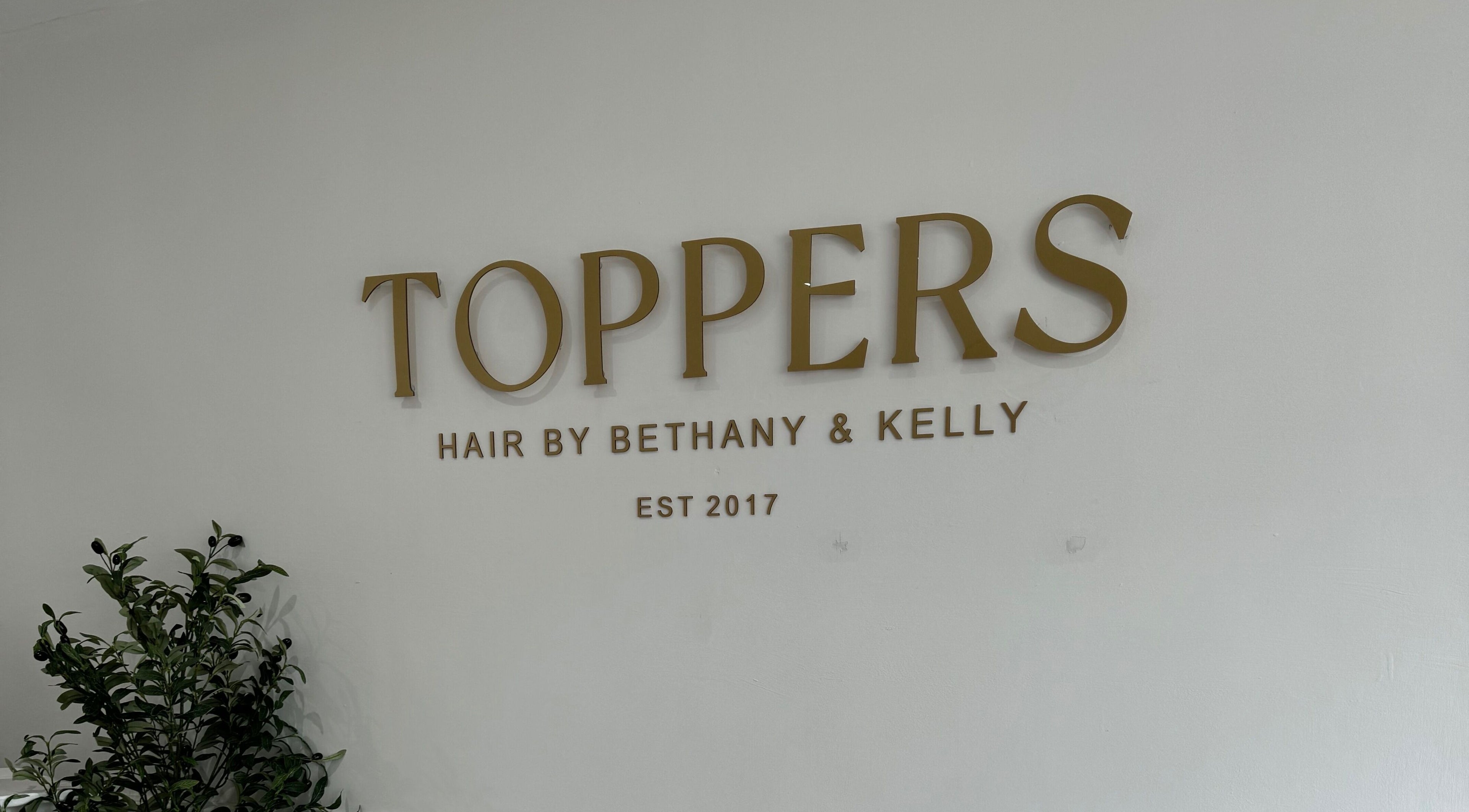 Elegant signage of Kelly Guppy Hair in Exeter, England, GB welcoming clients with style.
