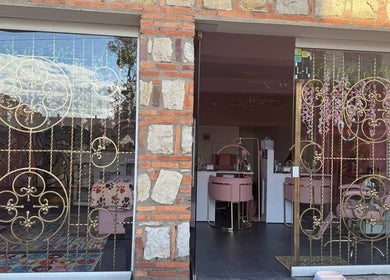 Elegant facade of Bloom Velvet Spa S.A.S in Bogotá, D.C., featuring intricate gold metalwork and pink decor.