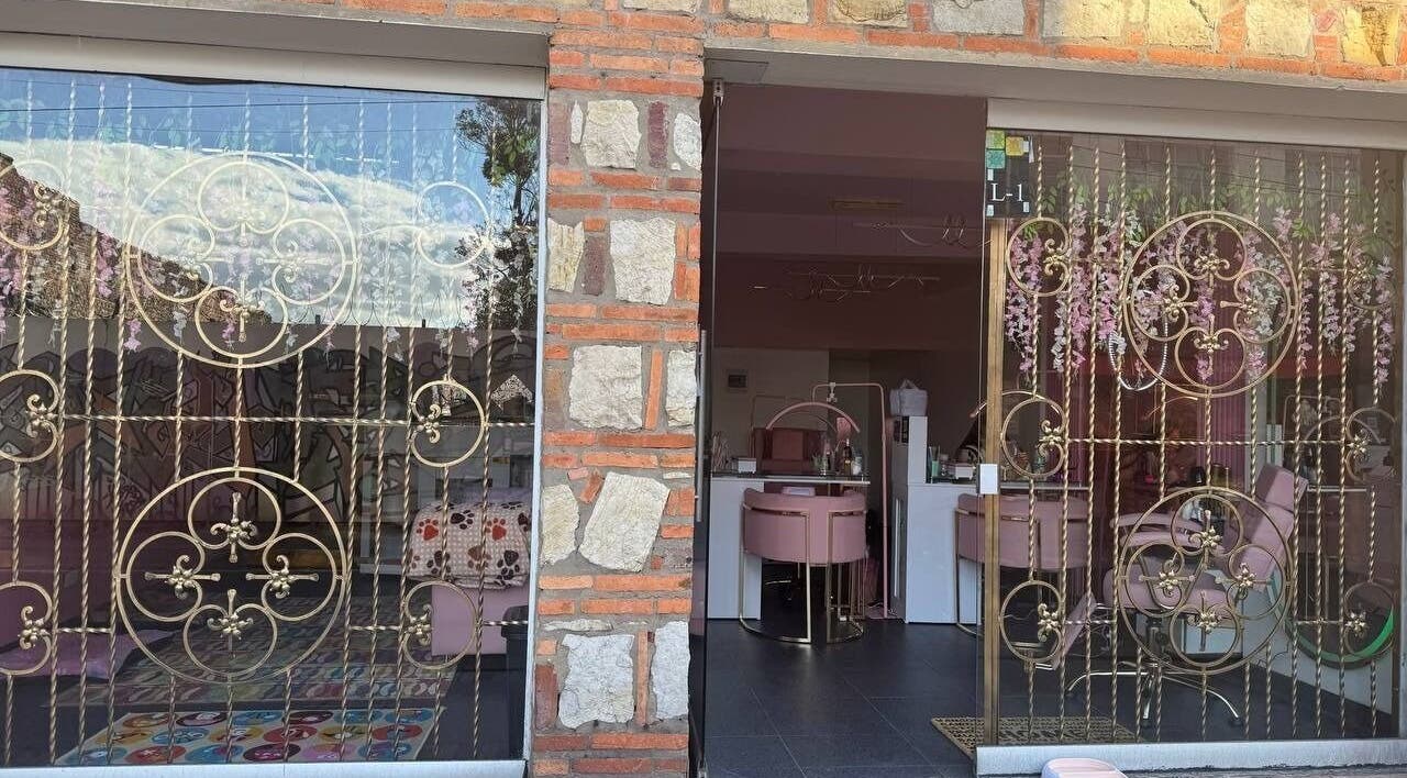 Elegant facade of Bloom Velvet Spa S.A.S in Bogotá, D.C., featuring intricate gold metalwork and pink decor.