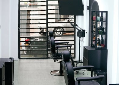 Zona de sillas y espejos en Bardos Salon, Medellín, Antioquia, CO, destacando diseño moderno y comodidad.