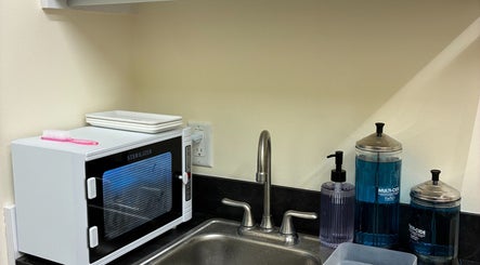 Clean sink area at One Drop Studio, Arcadia, California, US with sanitation supplies and a sterilizer.