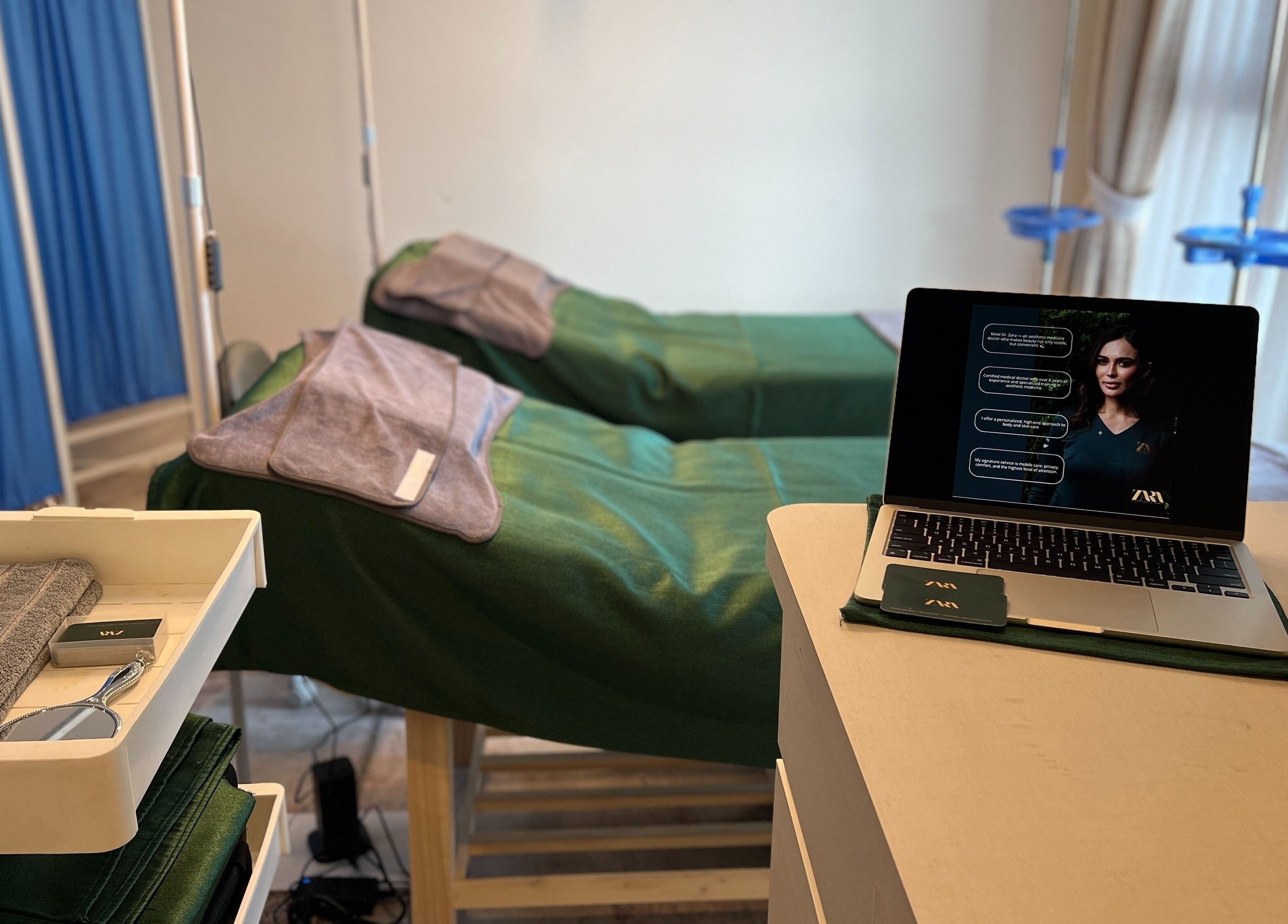 Cozy treatment room at Zara Aesthetic in Kuala Lumpur with green linens and laptop details.