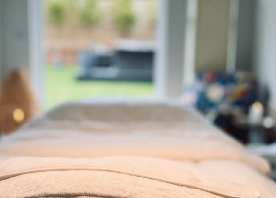 Relaxing massage bed at Kalma spa in Braintree, England, GB, overlooking a peaceful garden.
