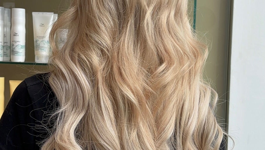 Stunning blonde waves styled at Belle Grace Hairdressing, Denton, England, GB salon. Bright, luxurious hair close-up.