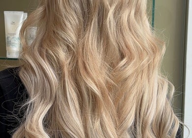 Stunning blonde waves styled at Belle Grace Hairdressing, Denton, England, GB salon. Bright, luxurious hair close-up.