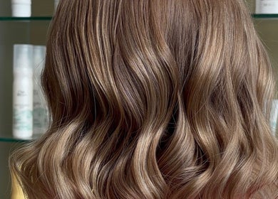 Stylish wavy hairstyle at Belle Grace Hairdressing, Denton, England, GB. Vibrant curls showcase expert hairdressing.