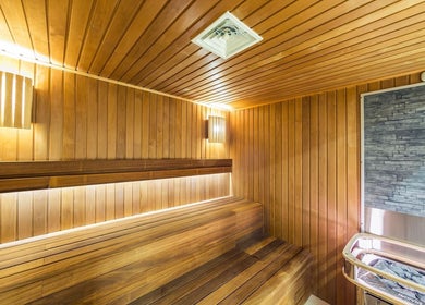Modern sauna at Wellness Center in Ulaanbaatar, Ulaanbaatar, MN featuring wood paneling and soft lighting.