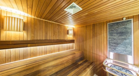 Modern sauna at Wellness Center in Ulaanbaatar, Ulaanbaatar, MN featuring wood paneling and soft lighting.