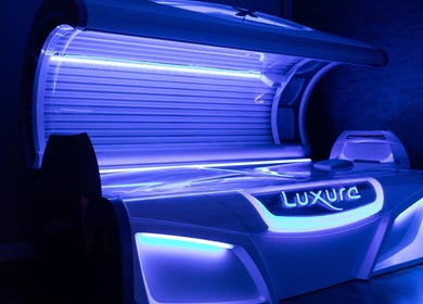 Modern tanning bed at Natural Bronze Tanning Salon in Braunton, England, GB, radiating a soothing blue light.