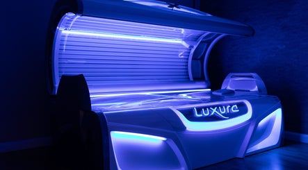 Modern tanning bed at Natural Bronze Tanning Salon in Braunton, England, GB, radiating a soothing blue light.