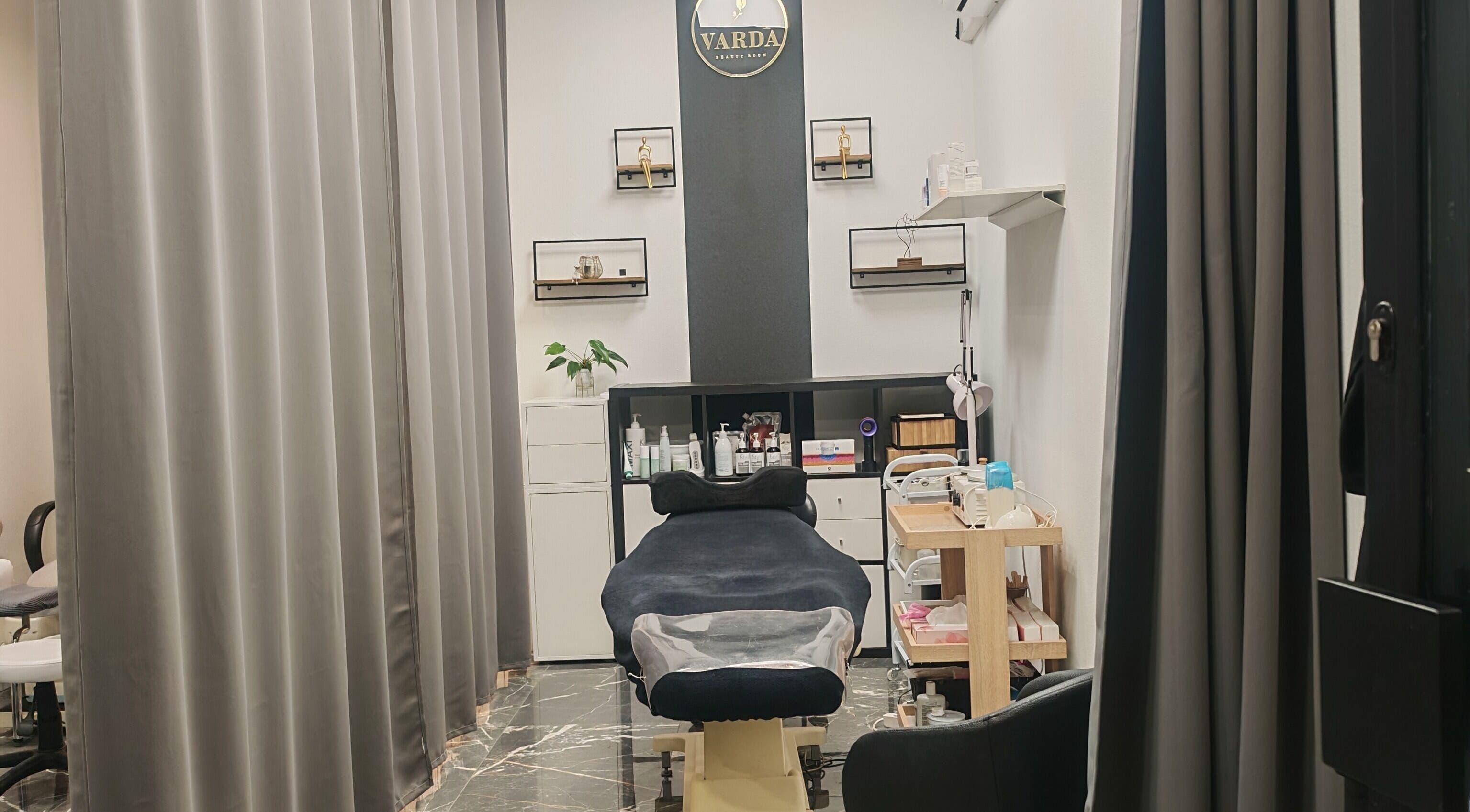 Varda Beauty Room, Mortsel, Vlaanderen, BE: stijlvolle verzorgingsruimte met luxe ligstoel en verzorgingsproducten.