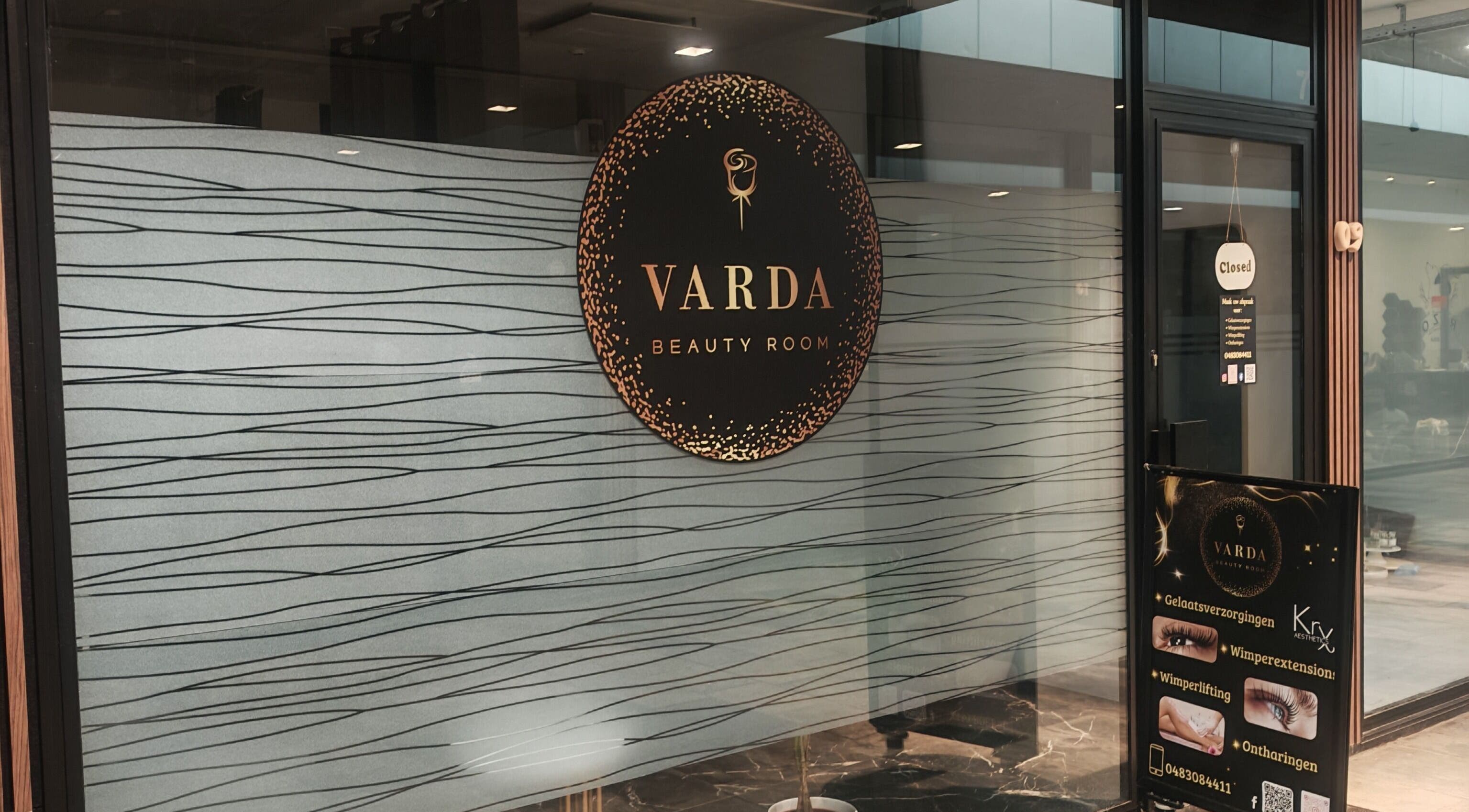 Ingang van Varda Beauty Room in Mortsel, Vlaanderen, BE met elegant logo op glazen deur.