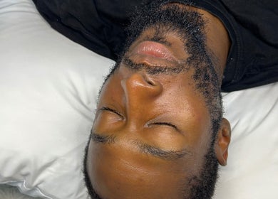 Client relaxing on a pillow at Luxe Mere’, London, England, GB, showcasing a calming wellness experience.