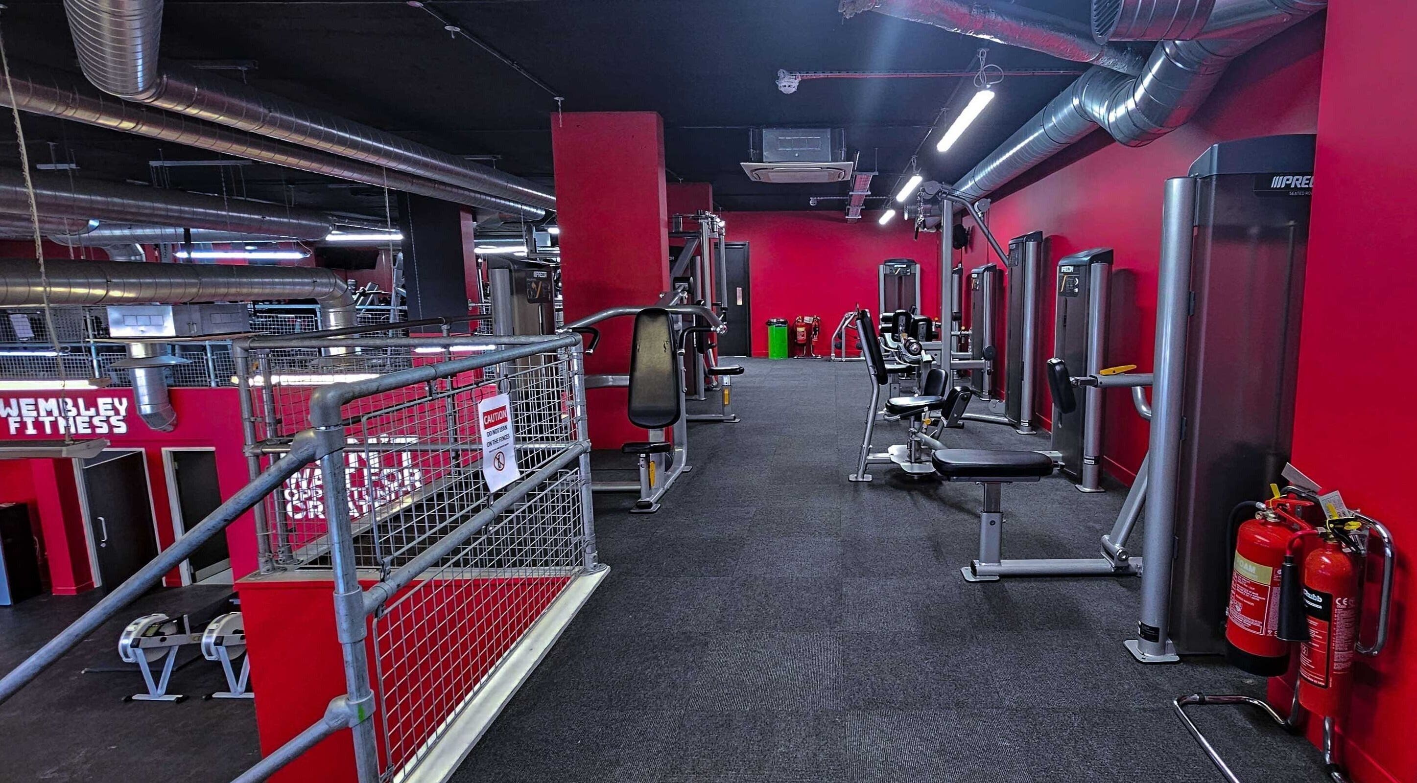 Modern fitness equipment at Wembley Fitness, Wembley, England, GB, featuring bold red and black decor.
