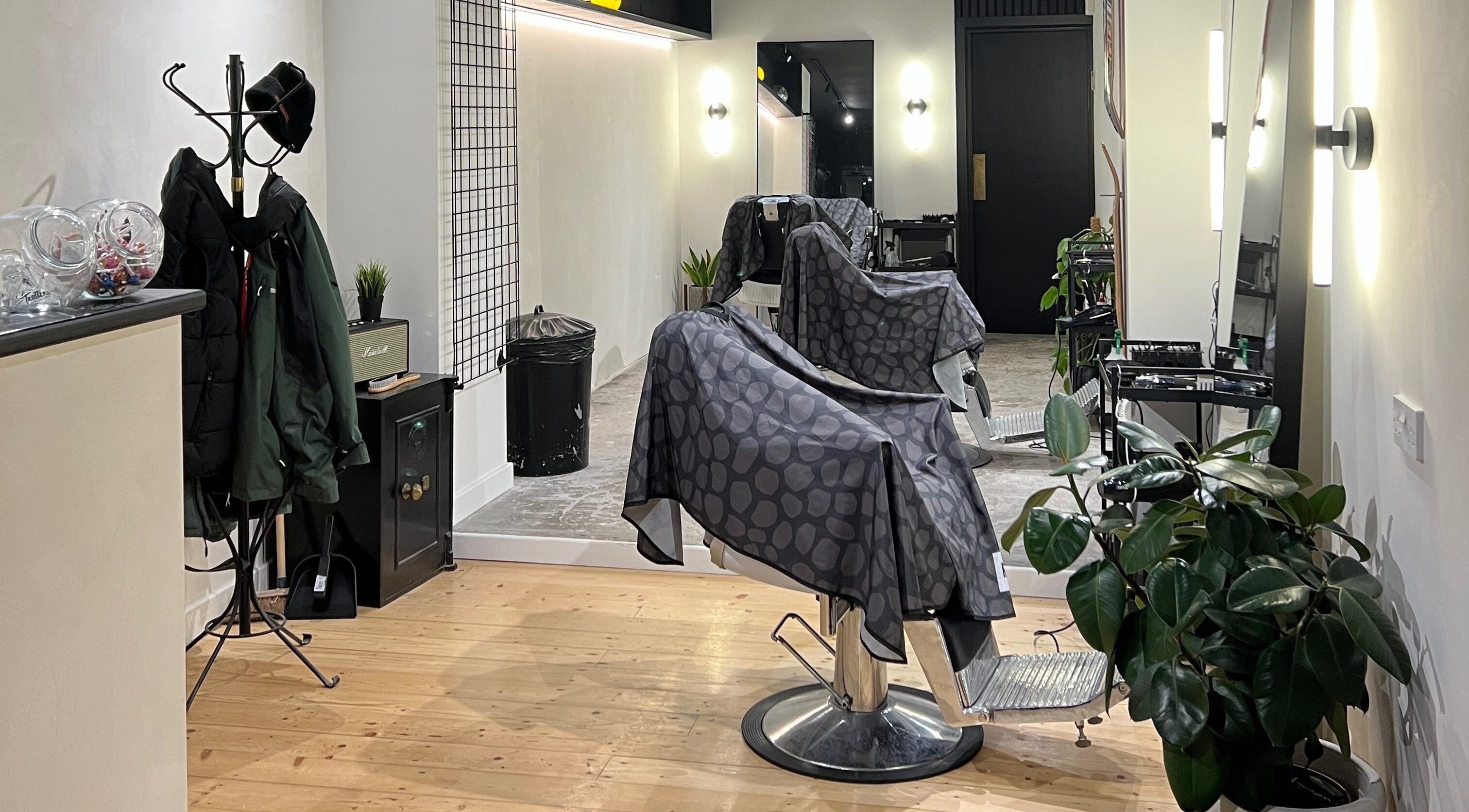 Stylish interior of Trotters Barber Shop in Alnwick, England, GB with modern chairs and a cozy ambiance.
