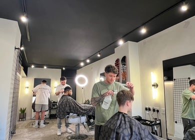 Professional barbers at Trotters Barber Shop, Alnwick, England, GB, styling clients' hair with precision.