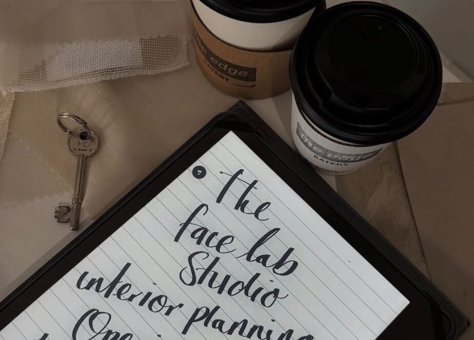 Notebook and coffee on a table at Just Jess, Witney, England, GB, showcasing creative interior plans.