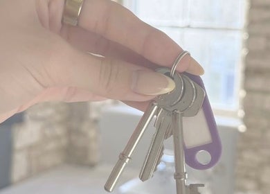 Hand holding keys at Just Jess, Witney, England, GB showcasing venue entrance.