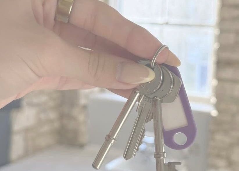 Hand holding keys at Just Jess, Witney, England, GB showcasing venue entrance.