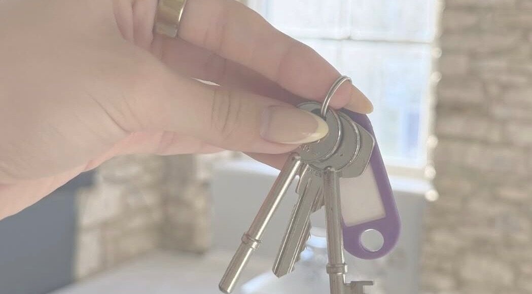 Hand holding keys at Just Jess, Witney, England, GB showcasing venue entrance.