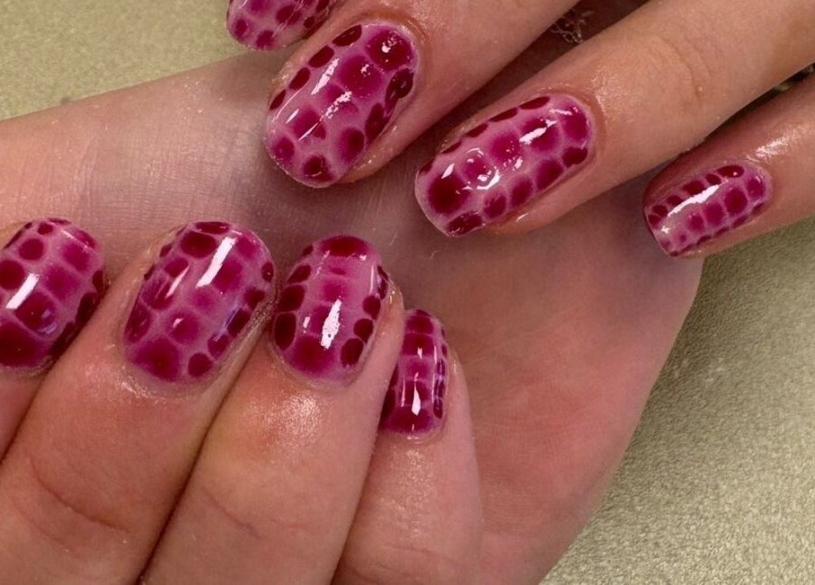 Stylish crimson dot-patterned nails at Nails & Beauty by Lucy, Ramey, Isle of Man, IM.