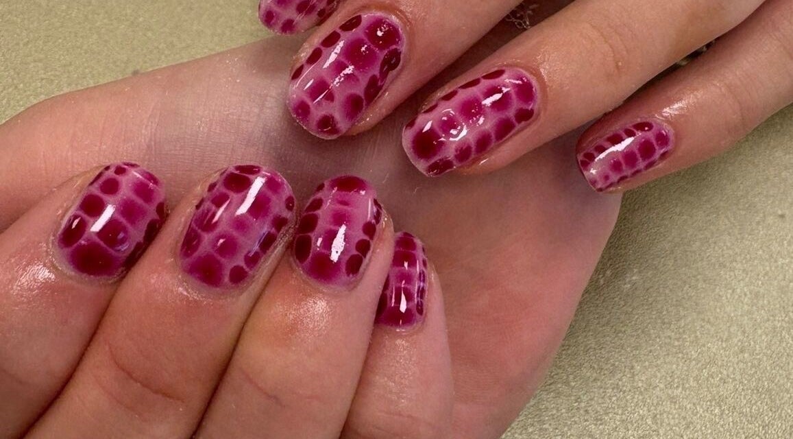 Stylish crimson dot-patterned nails at Nails & Beauty by Lucy, Ramey, Isle of Man, IM.