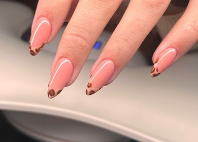 Elegant nail art with leopard print tips at Freyasbeautybar, Caterham, England, GB.