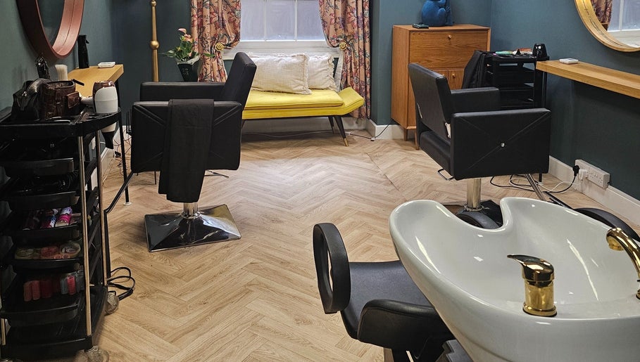 Elegant salon interior at Jolie Hairdressing in London, England, GB with chic decor and comfortable seating.