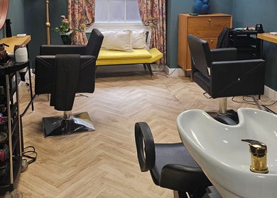 Elegant salon interior at Jolie Hairdressing in London, England, GB with chic decor and comfortable seating.