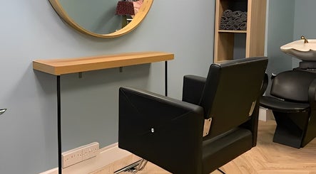 Modern salon chair and mirror at Jolie Hairdressing in London, England, GB, offering stylish haircuts.