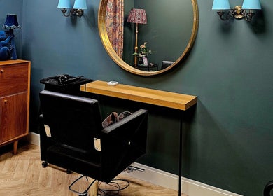 Jolie Hairdressing salon station with mirror, chair, and decor in London, England, GB reflects chic styling.