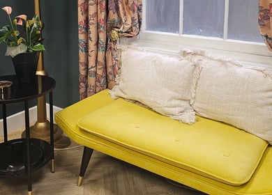 Chic seating area with a vibrant yellow couch at Jolie Hairdressing, London, England, GB.
