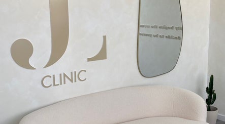 Sala de espera elegante no JL CLINIC, Linda-a-velha, Lisboa, PT, com sofá e espelho moderno.